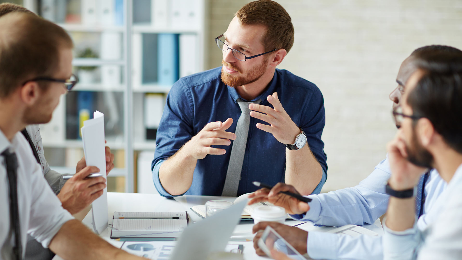 Young businessman listening to his colleague explanations and looking at him
