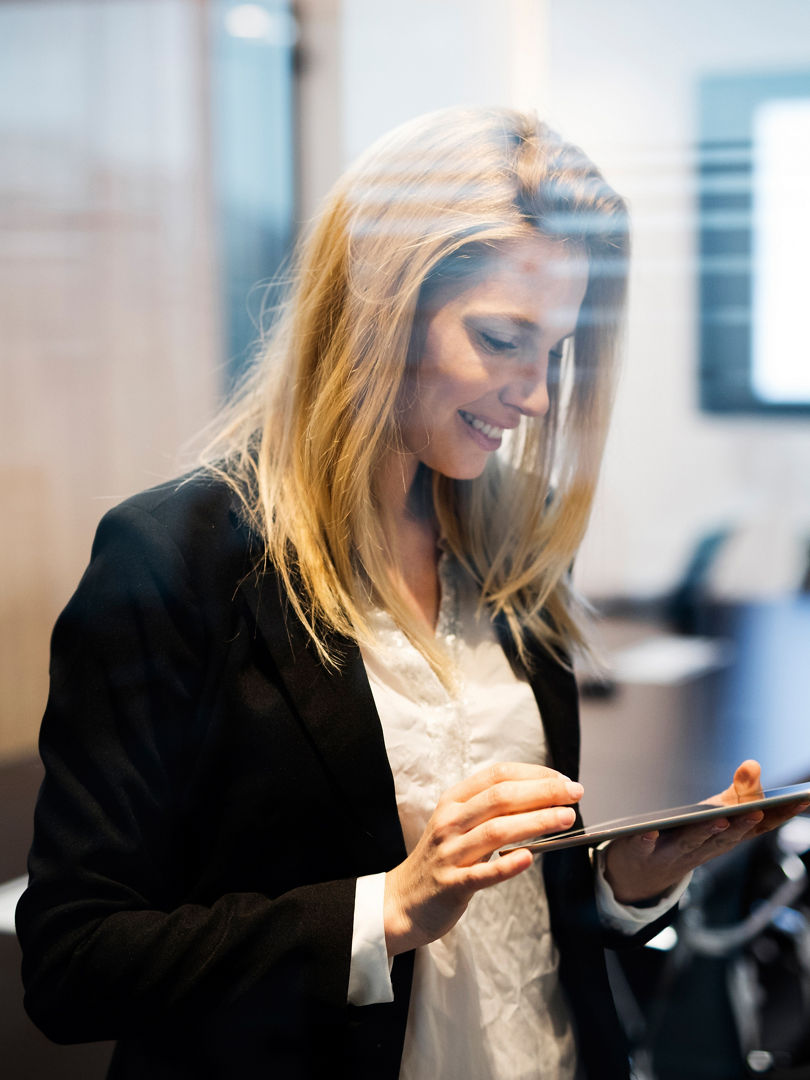 Portrait of beautiful blonde businesswoman holding tablet in conference room