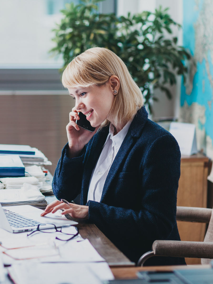 Young woman at the office talking on cellphone