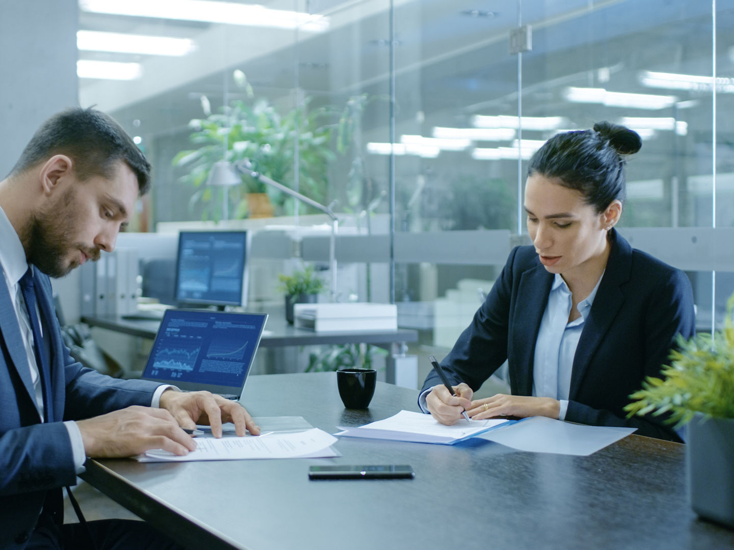 Businesswoman and Businessman Have Conversation. Draw up a Contract, Sign Documents, Seal the Deal, Finish Transaction, Come to an Agreement. They're in Modern Conference Room.