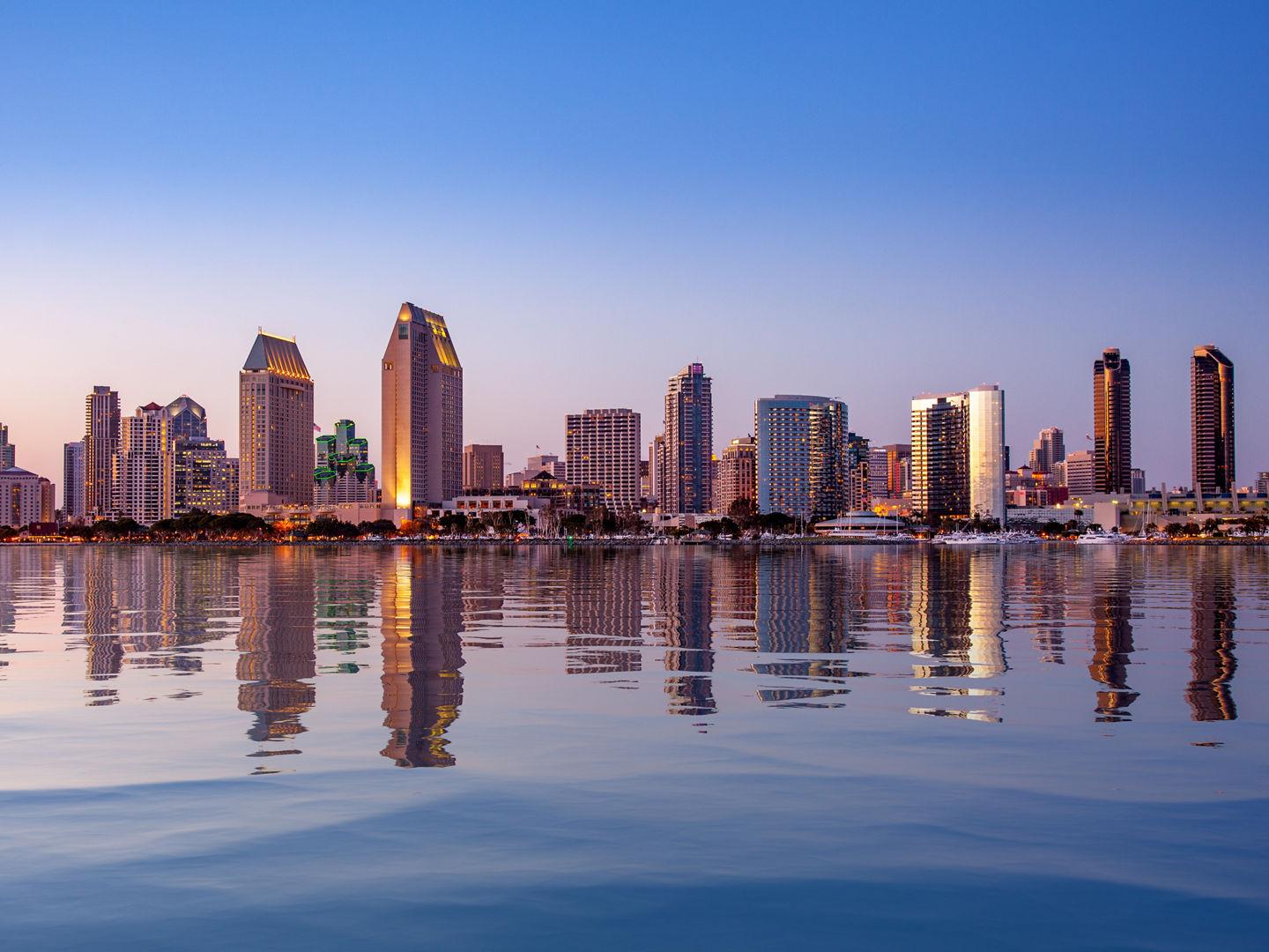 Sunset illuminating the tall skyscrapers of San Diego in California from Centennial Park in Coronado with artificial water reflection