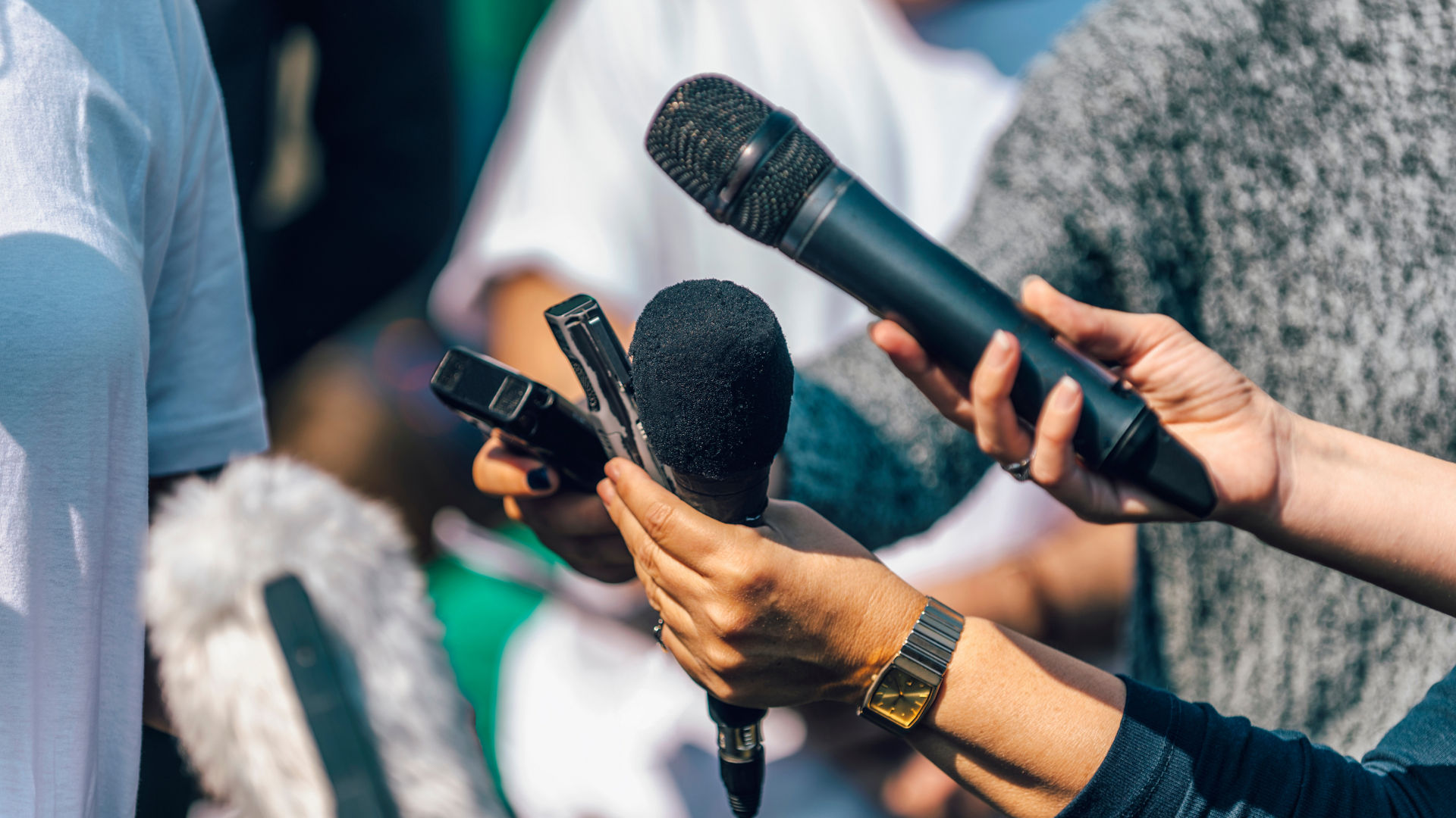 Journalists holding microphone and dictaphone, interviewing female speaker.