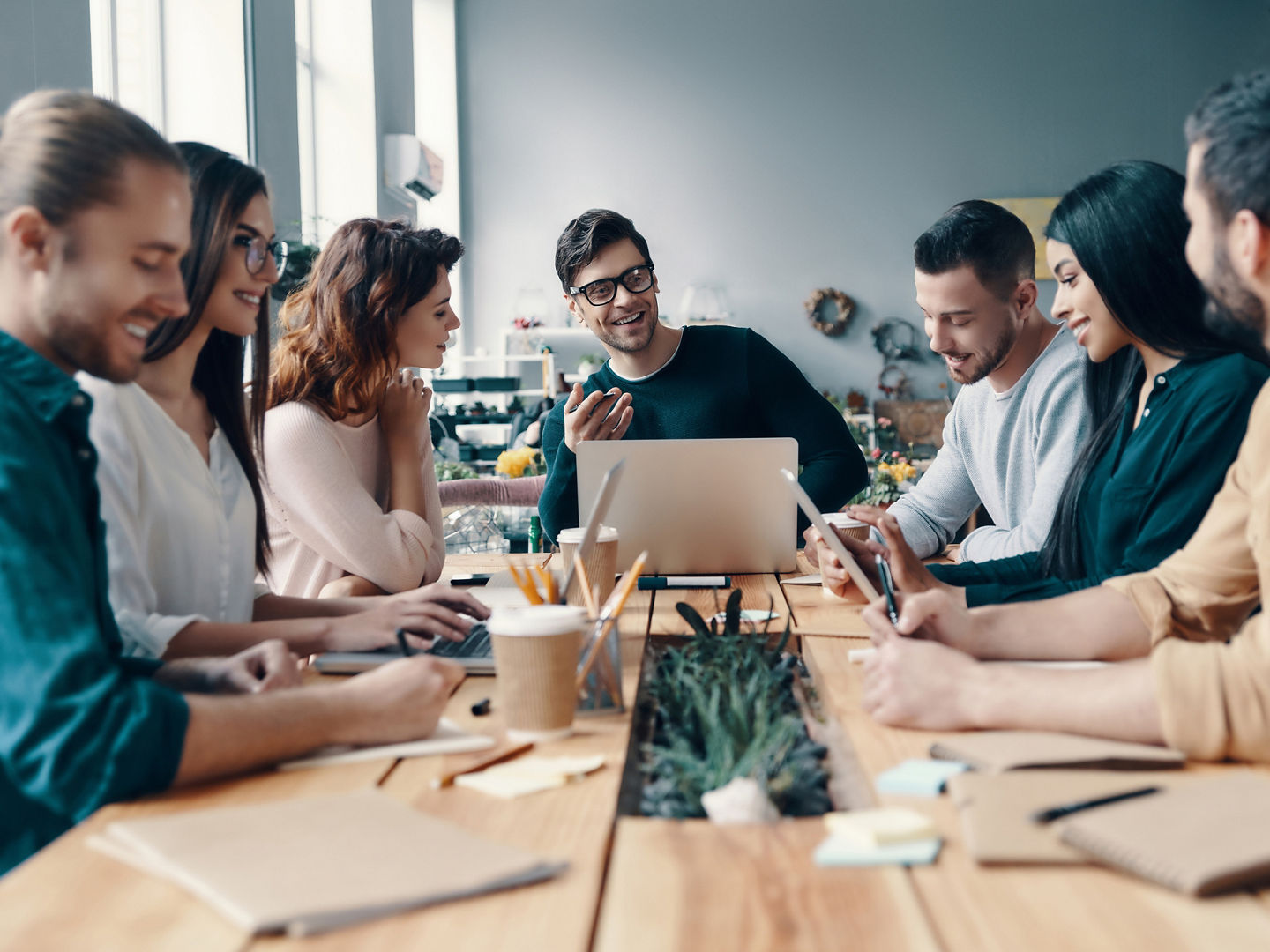 Marketing team. Group of young modern people in smart casual wear discussing something while working in the creative office              