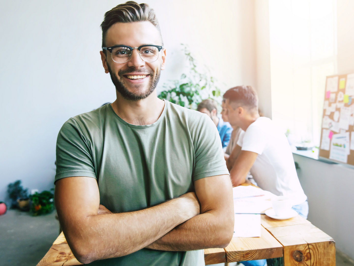 Handsome young business man in smart casual wear on background of brainstorming modern start up team in office or co-working centre, Handsome young business man in smart casual wear on background o