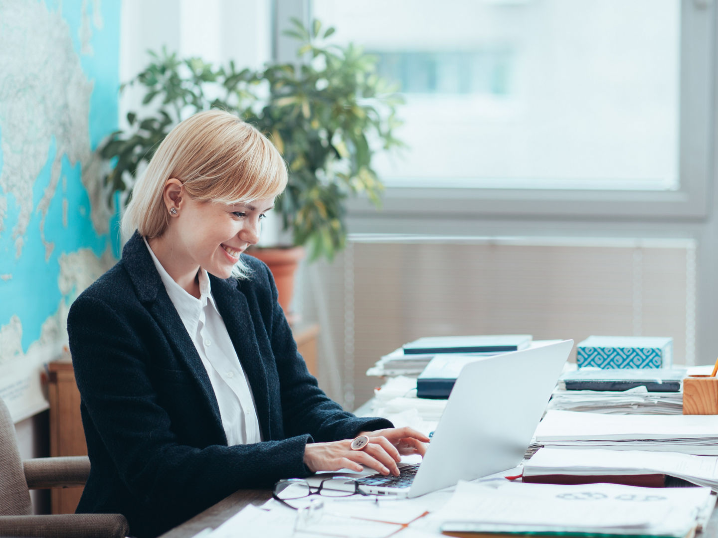 Woman in office working on a computer, writing an email