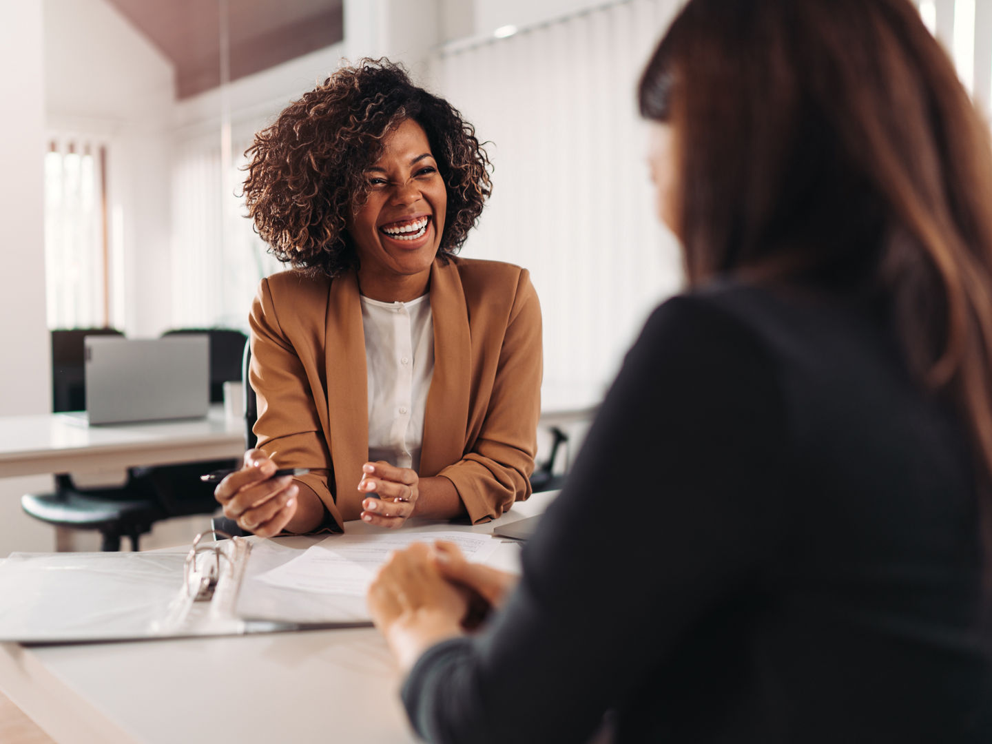 Female financial advisor consulting a client at the meeting and having business conversation or making offer