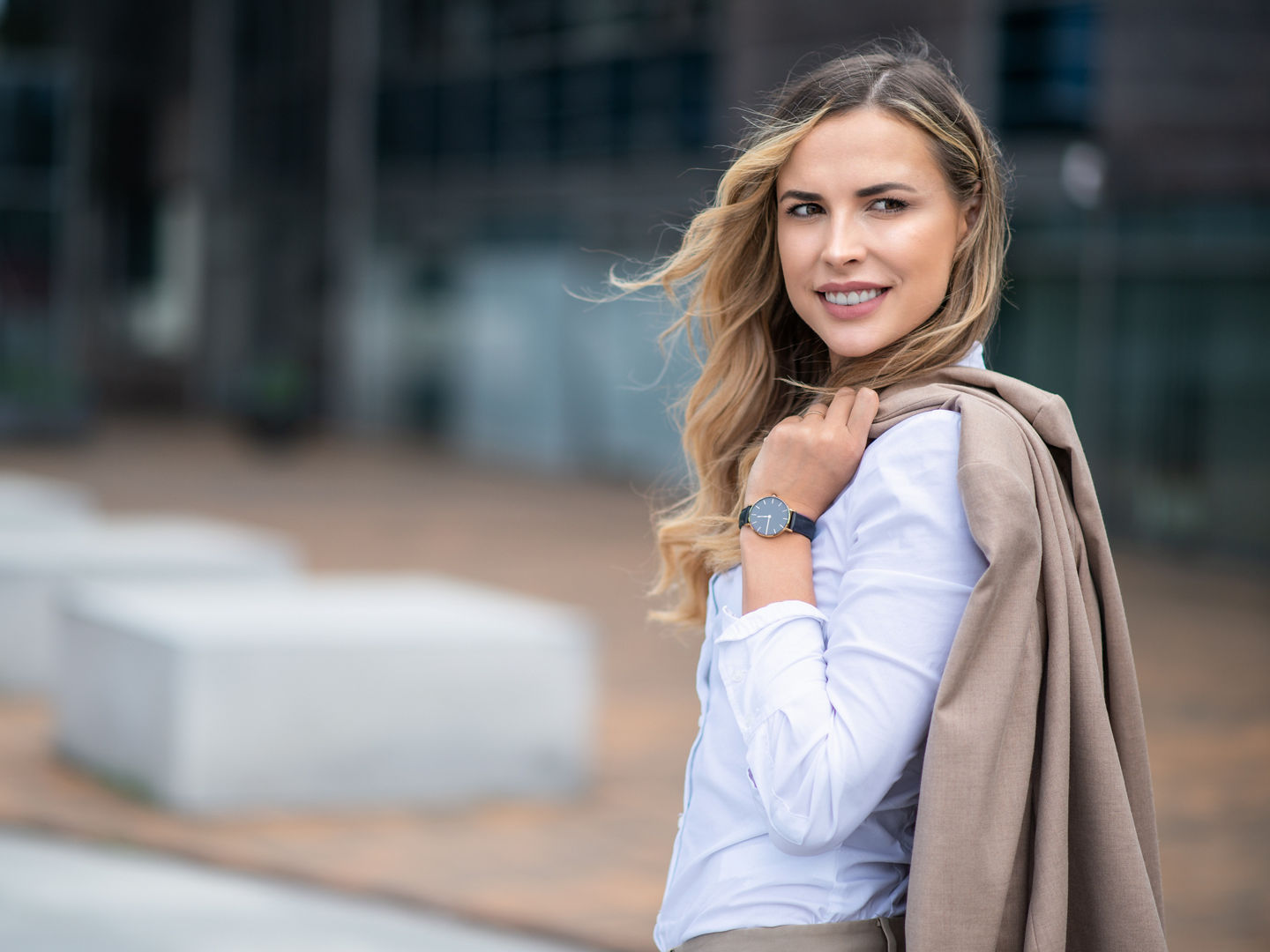 Portrait of a blonde smiling woman walking in a city district