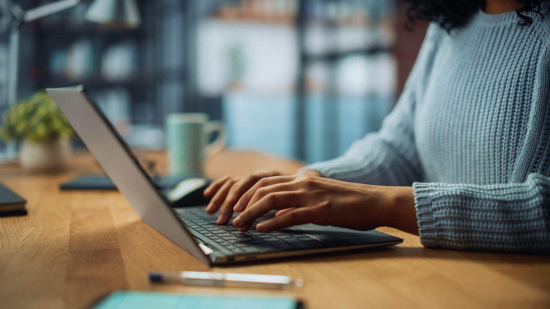 Close Up on Hands of a Female Specialist Working on Laptop Computer at Cozy Home Living Room while Sitting at a Table. Freelancer Woman Chatting Over the Internet on Social Networks.