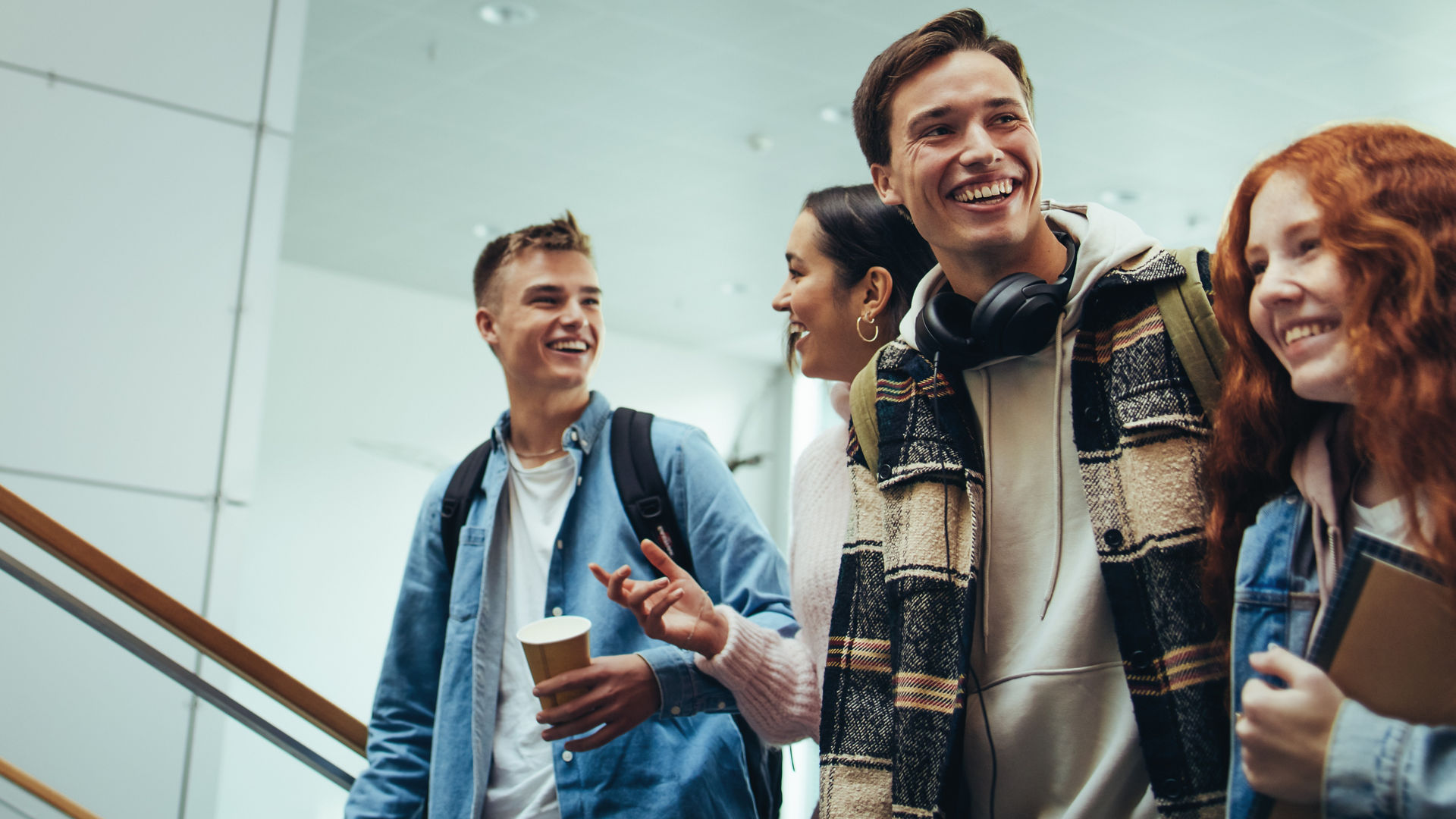 Group of young people walking and talking in university. College students going for their class.