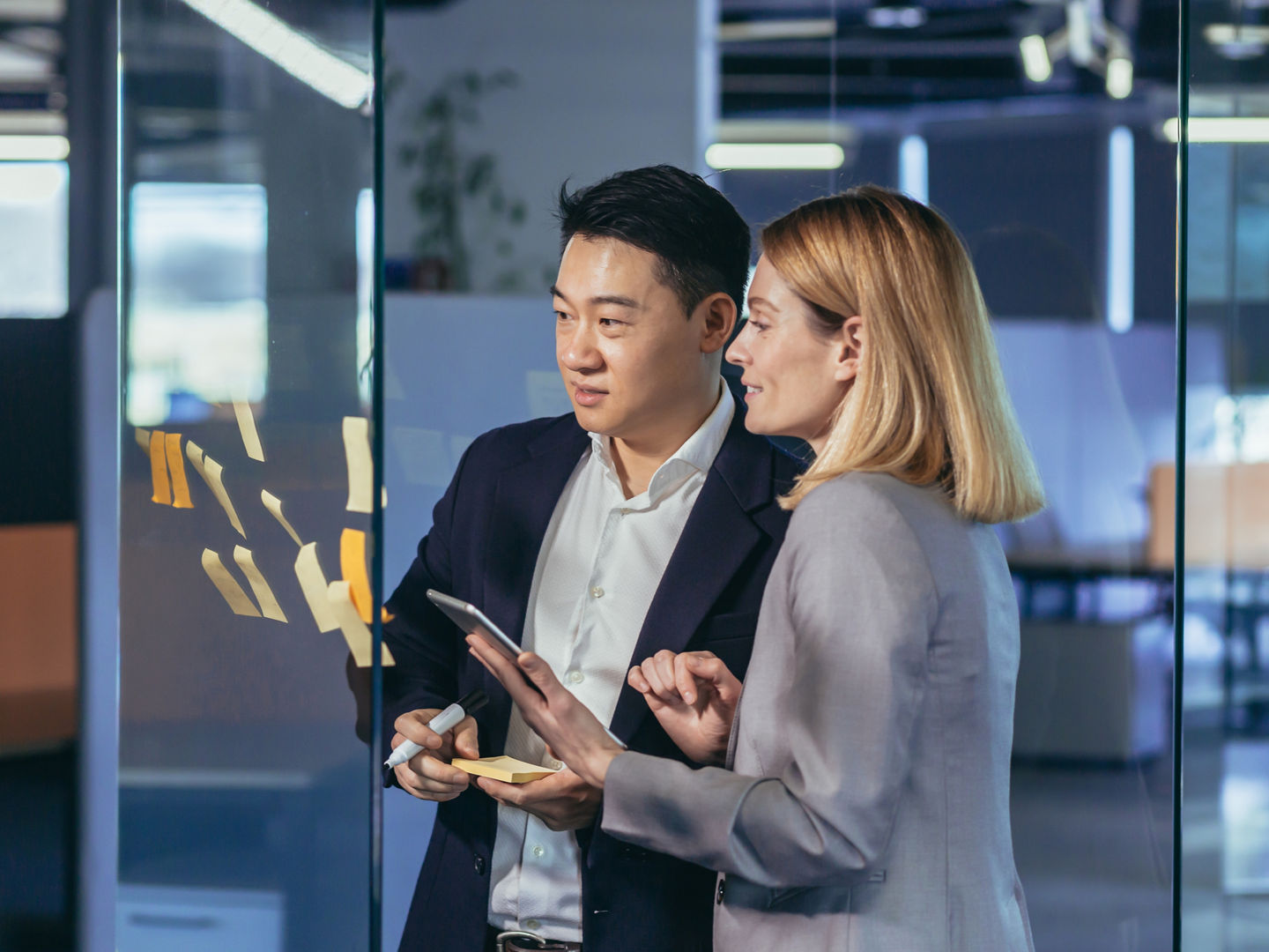 Team of business workers develop a business strategy, and develop a plan, an Asian man smiles at a female companion