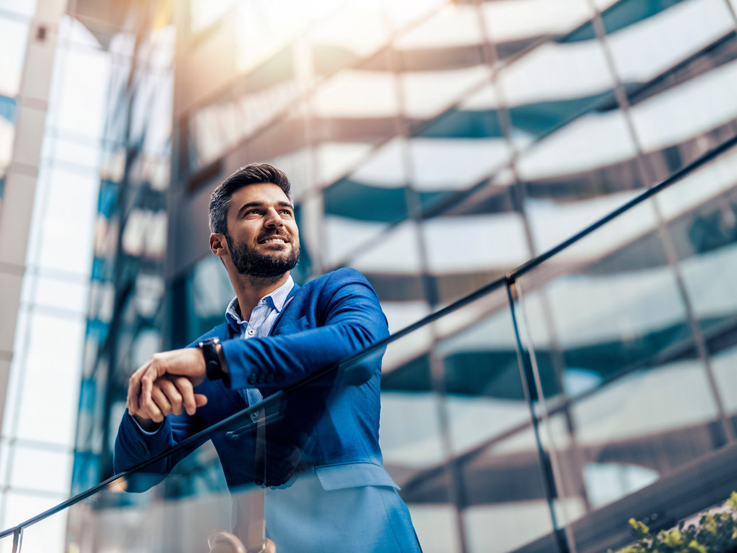 Handsome businessman portrait outdoor. He is standing in front of modern building.