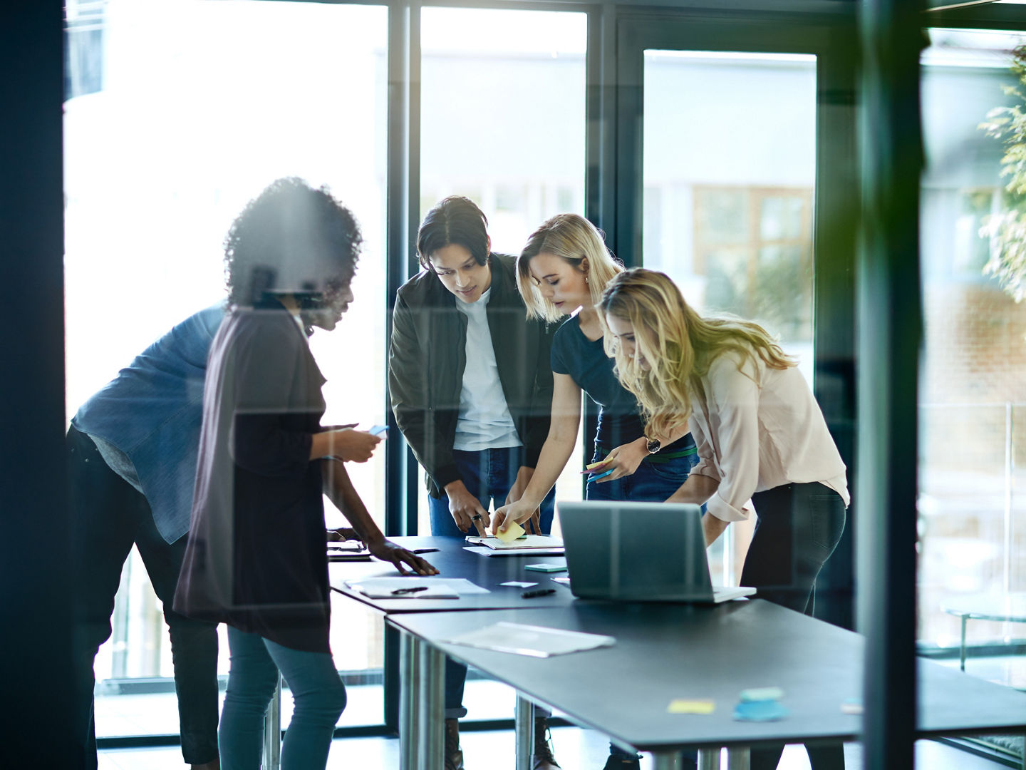 mMeting with team or group of businesspeople planning, brainstorming ideas and working on strategy for project in modern boardroom. Productive and diverse coworkers collaborating together.