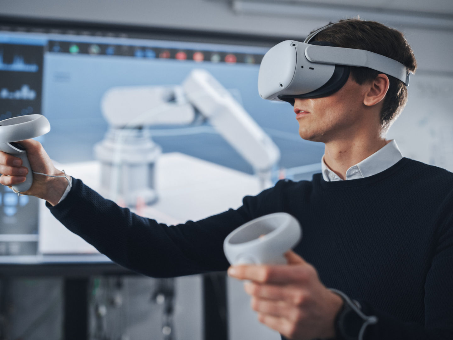 Student Engineer Wearing Virtual Reality Headset Holding Joysticks and Controlling Bionic Limb While Actions Displayed on Screen. Modern Equipment and Computer Science Education in University Concept., Student Engineer Wearing Virtual Reality Headset Holding Joystic