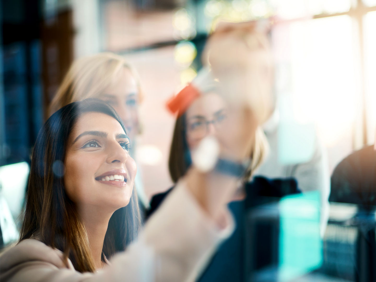 Smiling business woman working on teamwork success and meeting collaboration and writing on colorful notes. Successful female office worker making notes on a board. Marketing team planning a strategy.