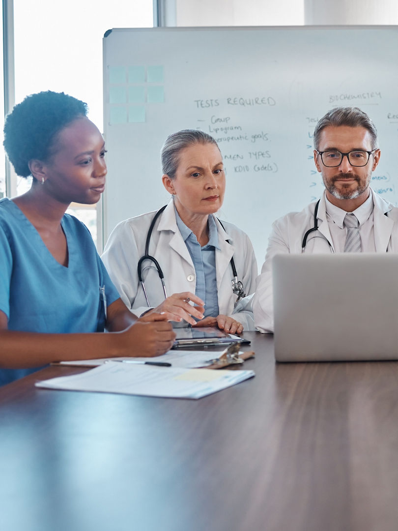 Hospital teamwork, laptop and healthcare planning, medical analytics and wellness collaboration of doctors, nurse and surgeon in meeting. Diversity, training or clinic workers consulting online tech.
