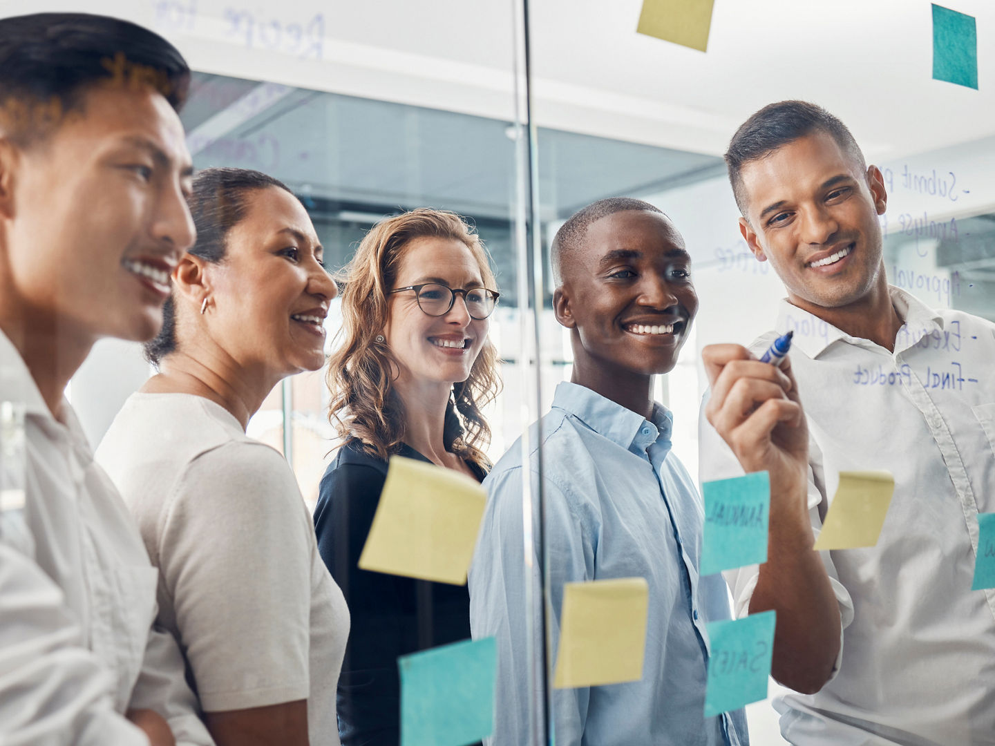 Business people, planning and team brainstorming with sticky notes for idea, strategy or collaboration at the office. Happy creative employee workers in post it, schedule or teamwork plan for project.