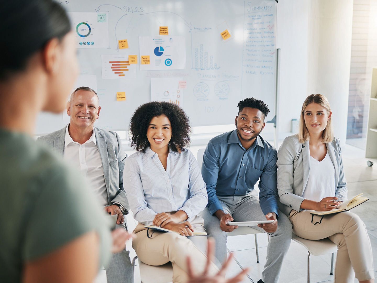 Presentation, marketing and business people in a meeting for training, sales workshop and happy at a group interview. Seminar, learning and employees listening to a mentor teaching a strategy.