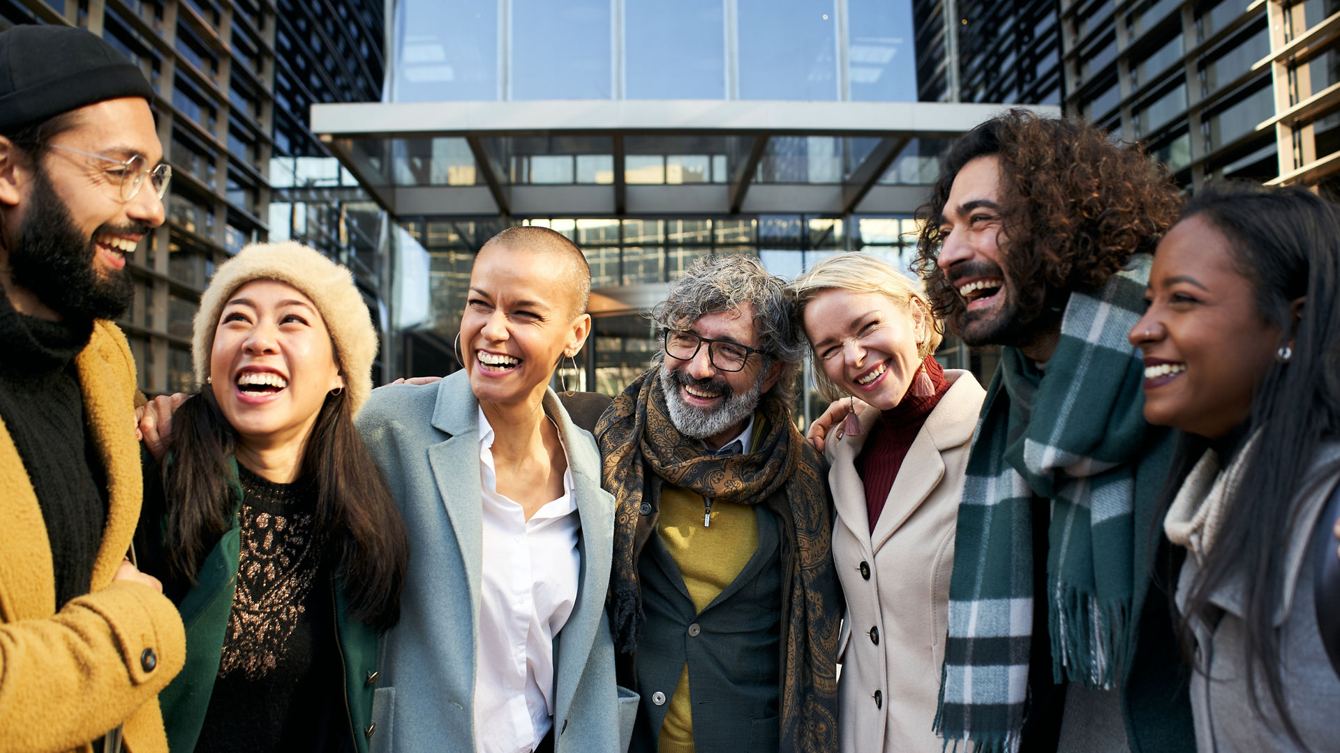 Business team working smiling portrait, talking and laughing. Man and women outdoors together in modern office celebrate success at work company. High quality photo