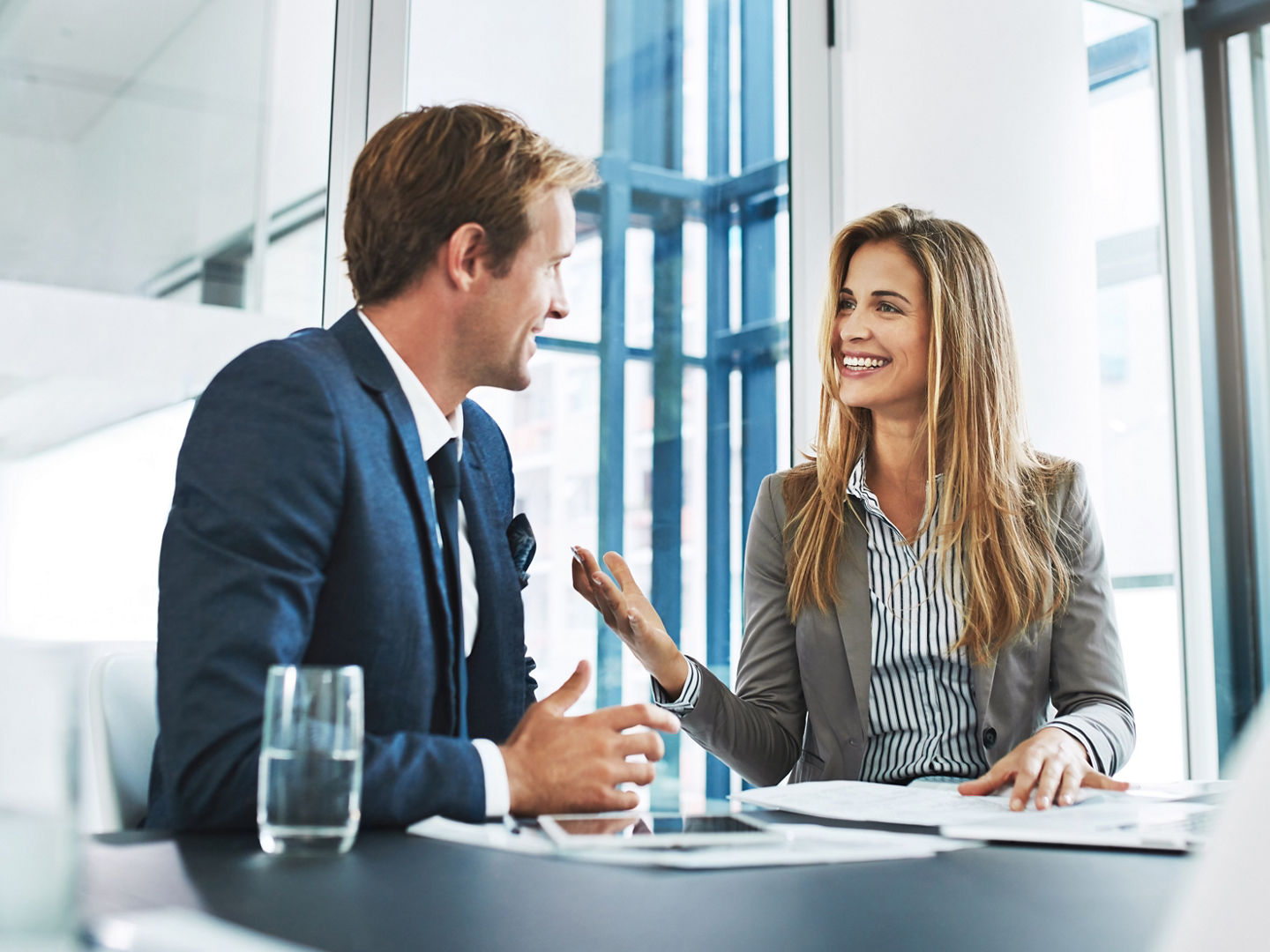 Corporate, staff and employees with collaboration, meeting and feedback in an office, happiness and conversation. Partnership, man and woman with startup success, talking and planning with target.