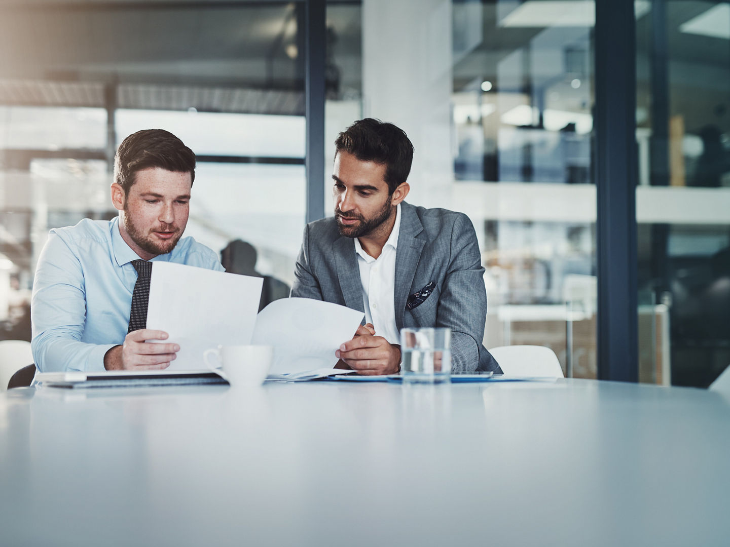 Meeting, documents and businessmen in discussion in the office boardroom planning a corporate strategy. Brainstorming, collaboration and male employees working on project with paperwork in workplace