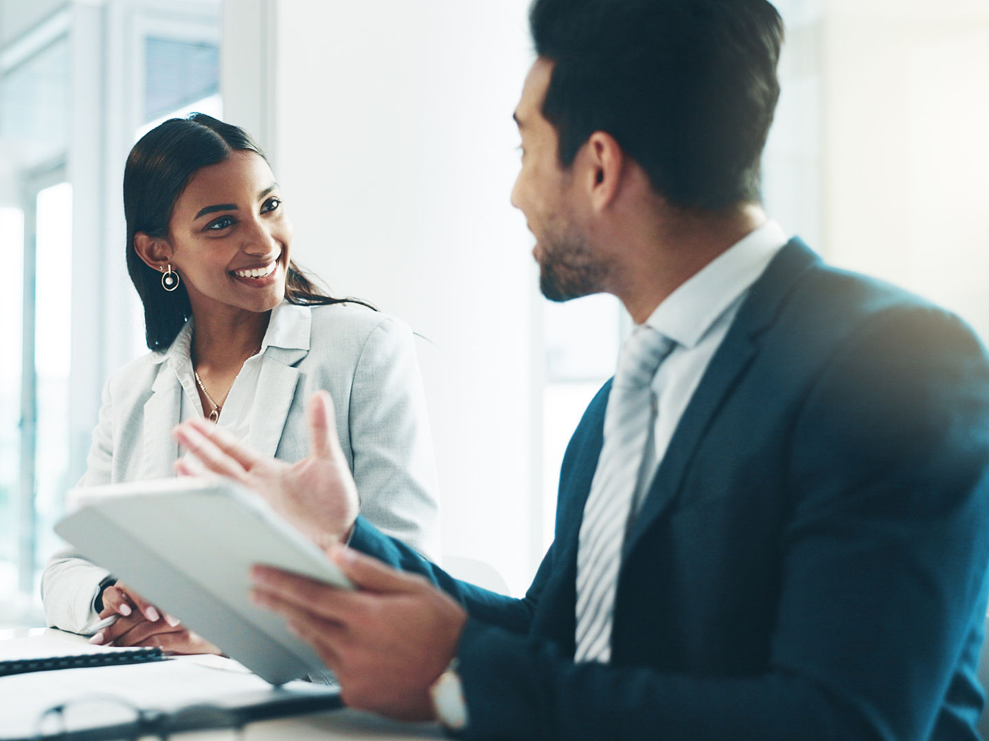 Tablet, meeting and partnership with business people working in an office as a team for research. Technology, planning or teamwork with a man and woman employee reading information in the workplace.