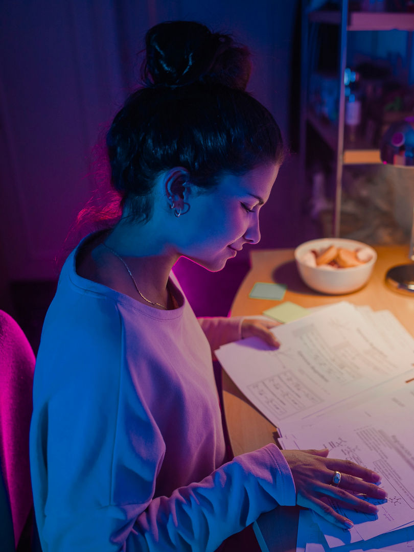 University girl smiles and studying in her room with neon lights