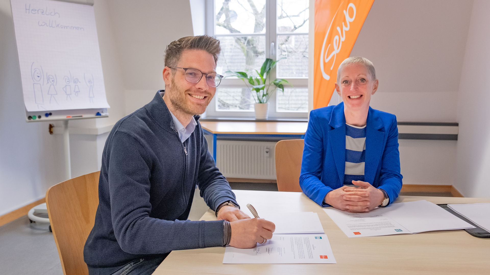 Patrick Klahold (SeWo GmbH) und Birgit Lippmann (FOM in Wesel) unterzeichnen die Kooperationsvereinbarung. (Foto: FOM)