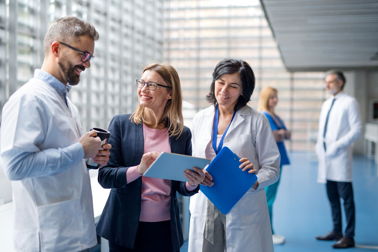 Group of doctors talking to pharmaceutical sales representative on conference.