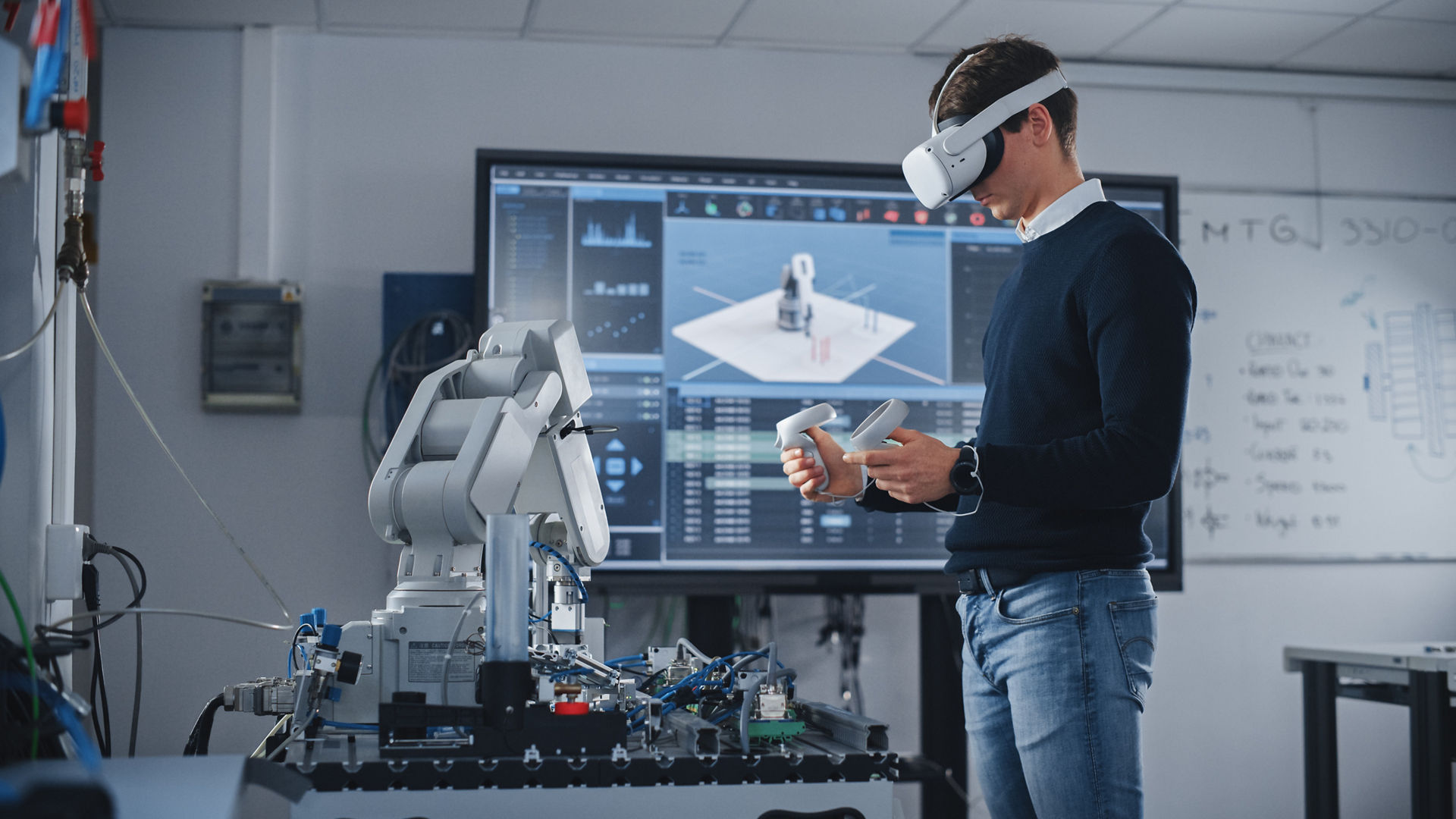 Student Engineer Using Virtual Reality Software for His Project. Man with Headset and Controllers Studying at Modern University in Classroom. Futuristic and High Tech Concept.